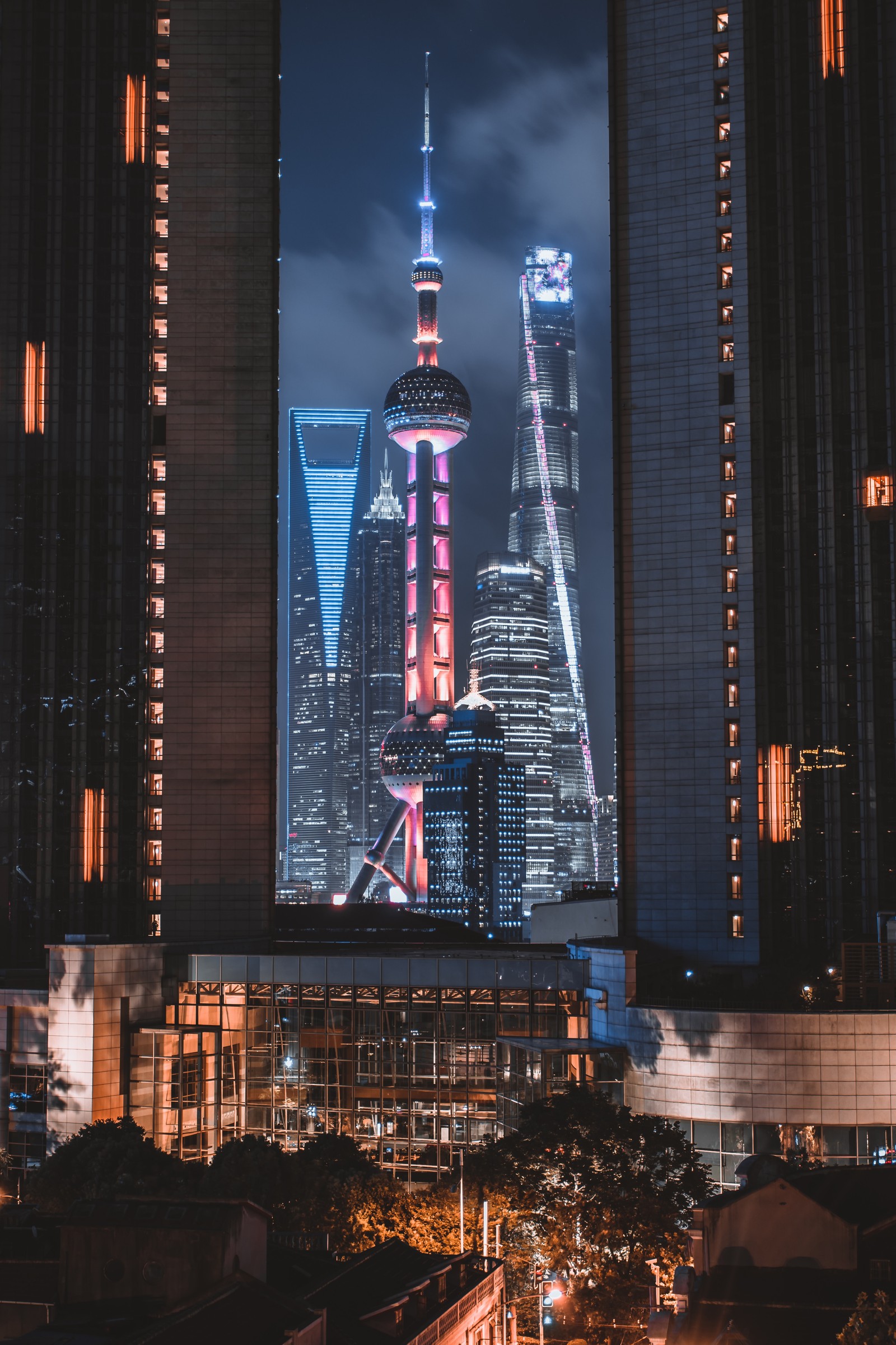 Vue nocturne d'une ville avec de grands bâtiments et une horloge (ville, bâtiment, design, gratte ciel, établissement humain)