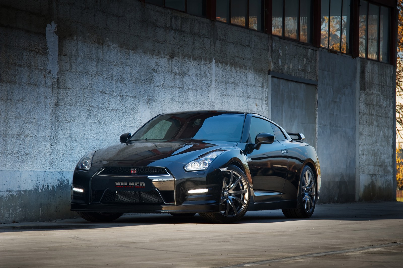 A close up of a black sports car parked in front of a building (nissan, car, car tuning, sports car, supercar)