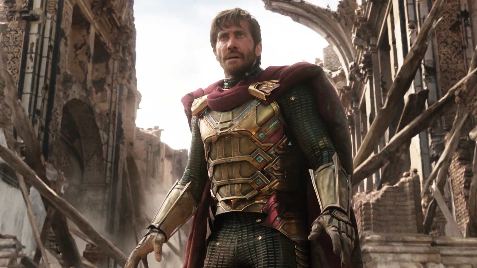 Un homme en armure se tient dans une ville en ruines (spider man loin des siens, spider man far from home, film, mysterio, jake gyllenhaal)