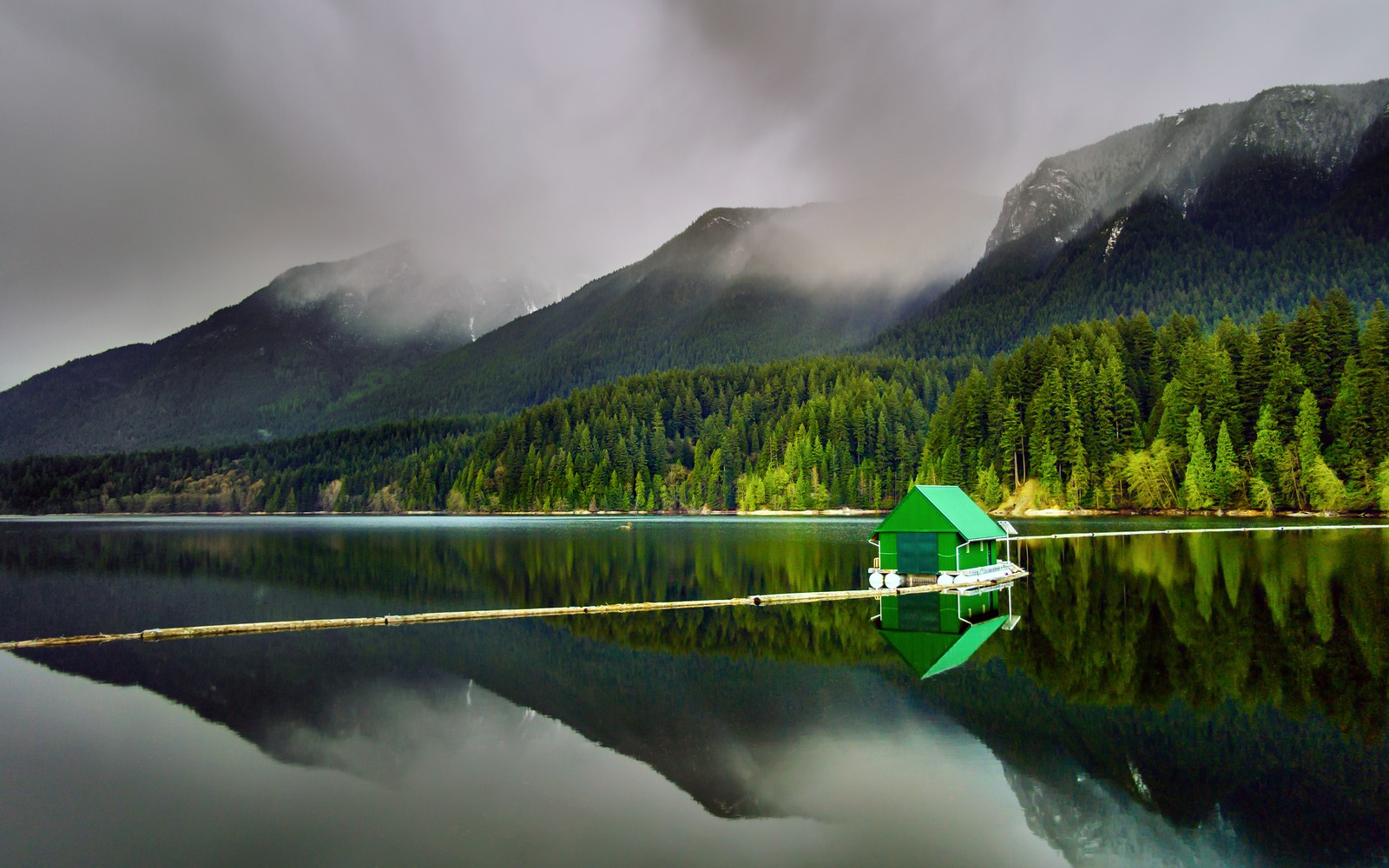 Uma pequena casa verde em um pequeno lago nas montanhas (floating cabin, capilano lake, north vancouver, paisagem, árvores verdes)