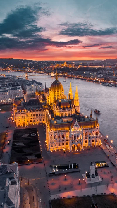 Impresionante paisaje urbano al anochecer: Edificio del Parlamento húngaro iluminado con vista al río