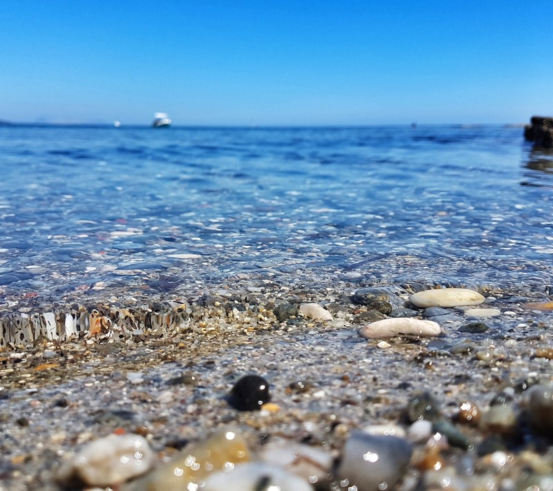 Вдалеке на воде маленькая лодка (пляж, фотография, небо, лето, вода)