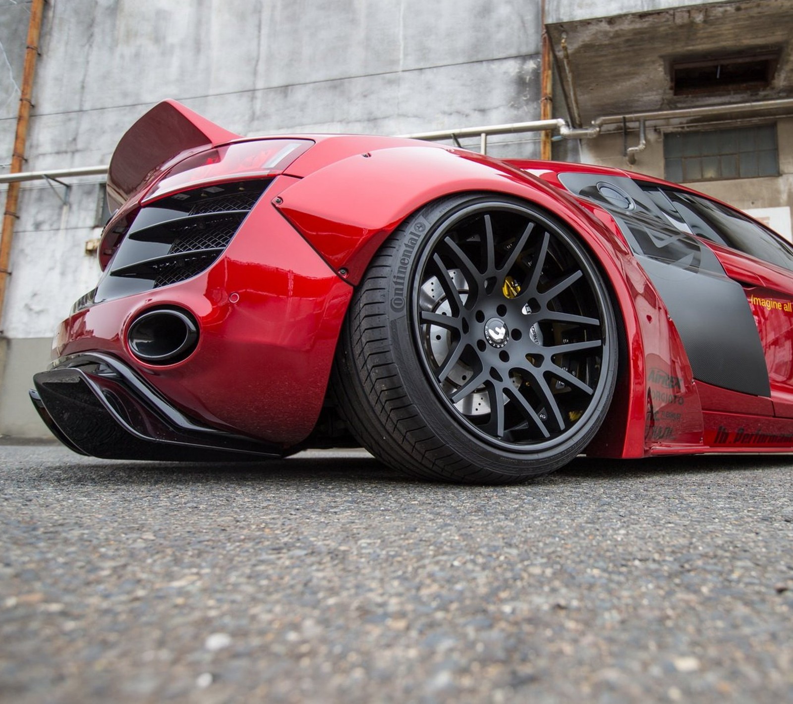 Un primer plano de un coche deportivo rojo estacionado frente a un edificio (audi, coche, modificado)