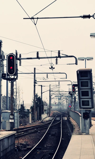 Gare urbaine avec signaux rouges et voies en lumière HD