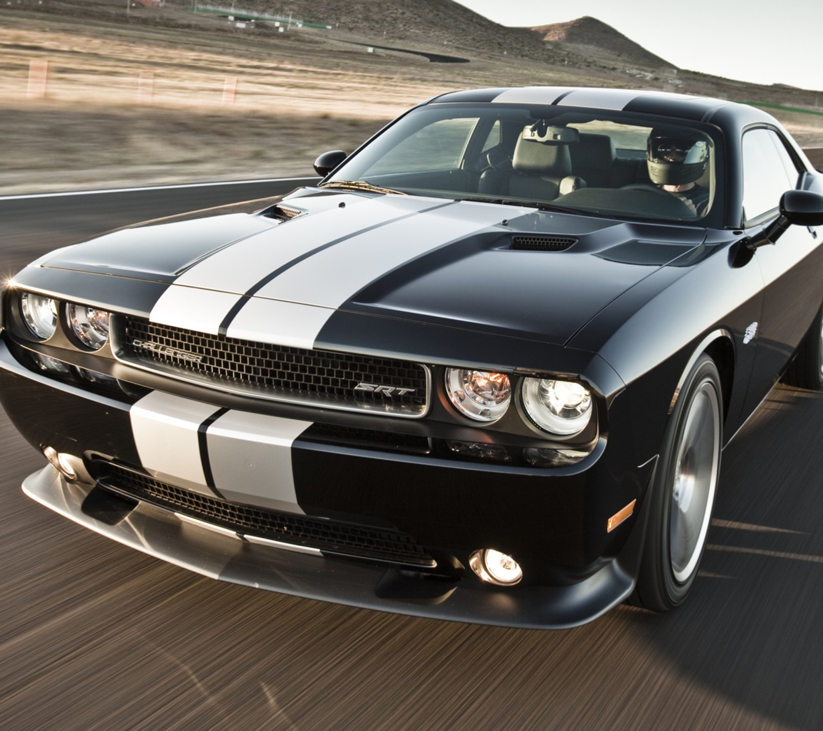 Nahaufnahme eines schwarz-weißen autos, das auf einer straße fährt (schwarz, herausforderer, dodge, mustang)