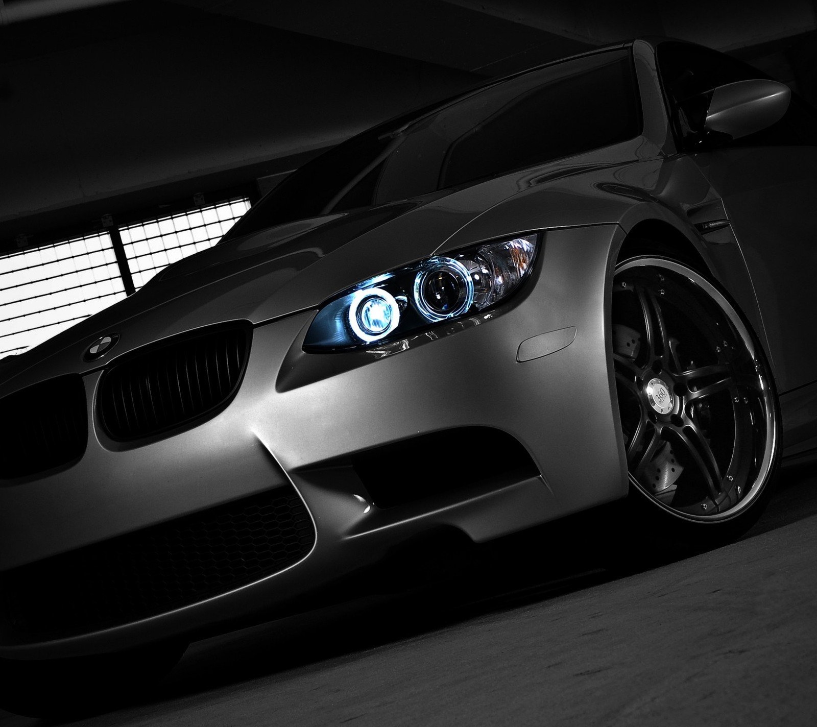 A close up of a car with a bright headlight in a garage (auto, bmw, car, sport, vehicle)