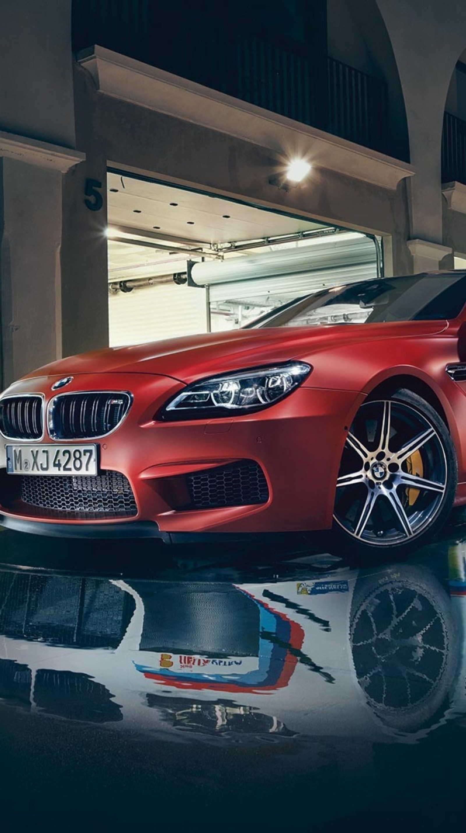 A close up of a red bmw car parked in a garage (bmw, building, dtm, night, reflection)