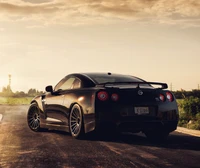 Eleganter schwarzer Nissan GT-R vor dramatischem Sonnenuntergang