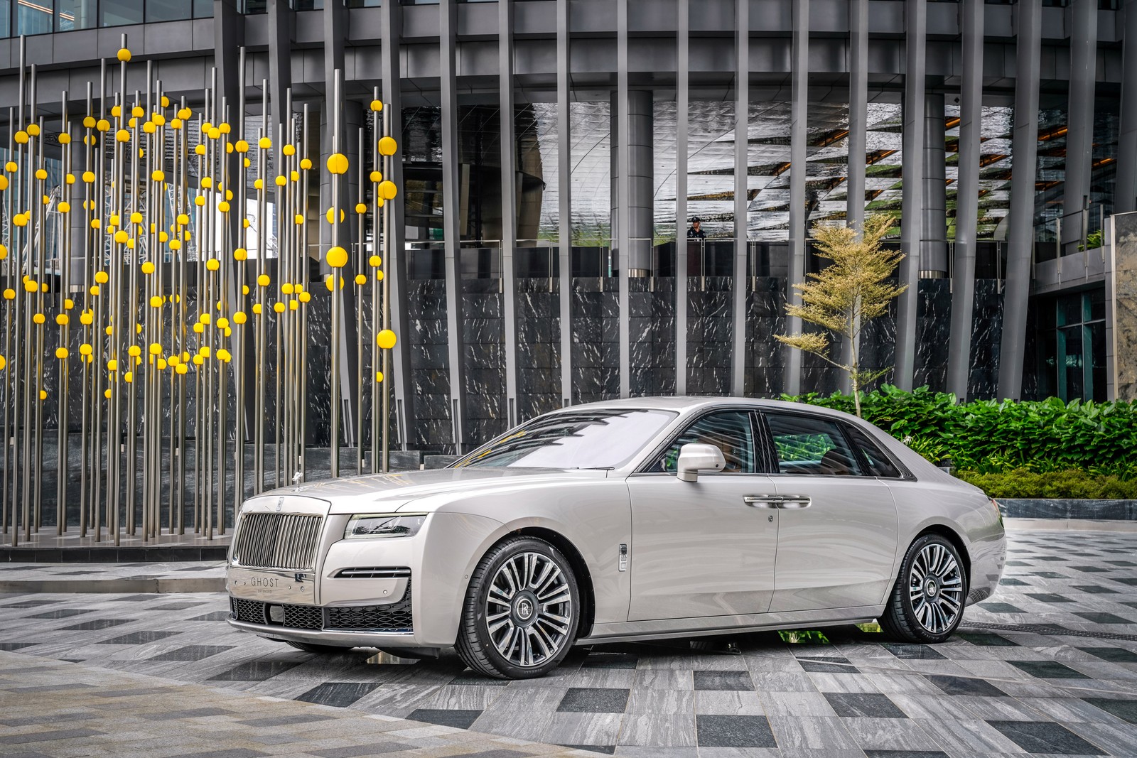 Белый роллс-ройс припаркован перед зданием с желтым деревом (rolls royce ghost ewb, 2021, машины, обои 4k)