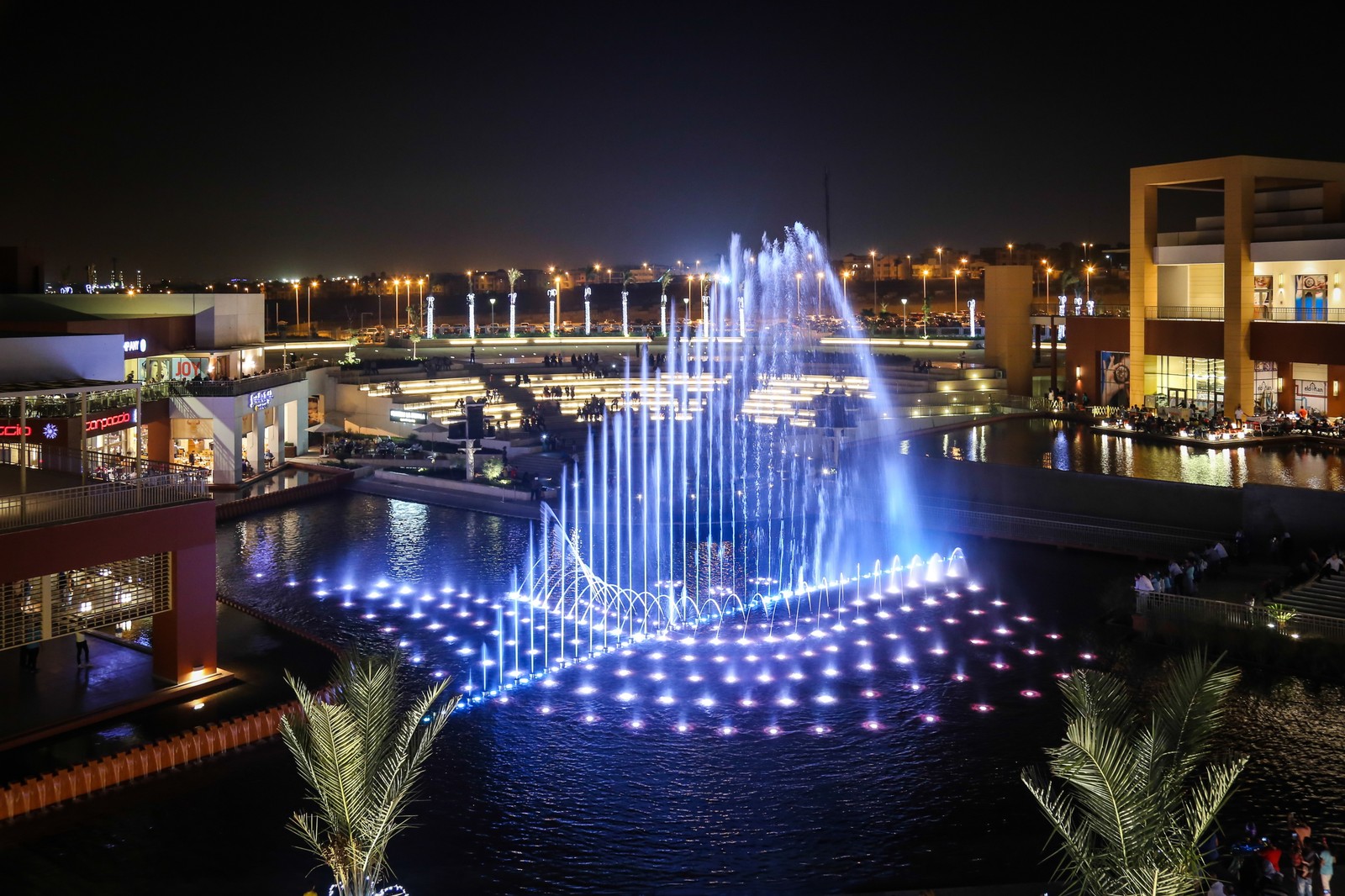 Uma fonte iluminada em um shopping à noite (fonte, água, noite, elemento de água, iluminação)