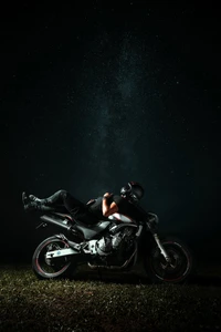 Nighttime Serenity: Biker Relaxing Under a Starry Sky on a Honda