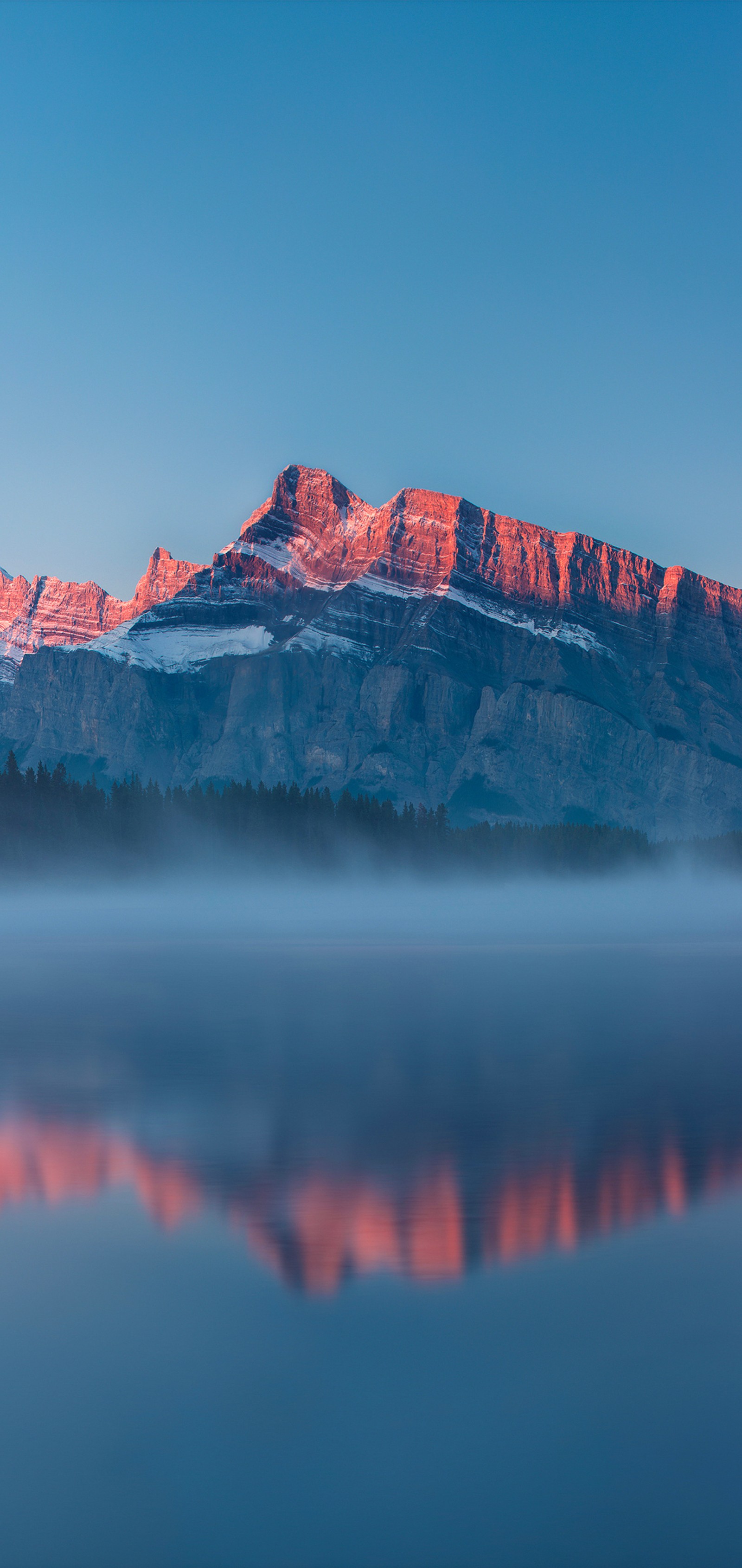 Mountains are reflected in the water of a lake with a pink hue (water, atmosphere, mountain, azure, natural landscape)