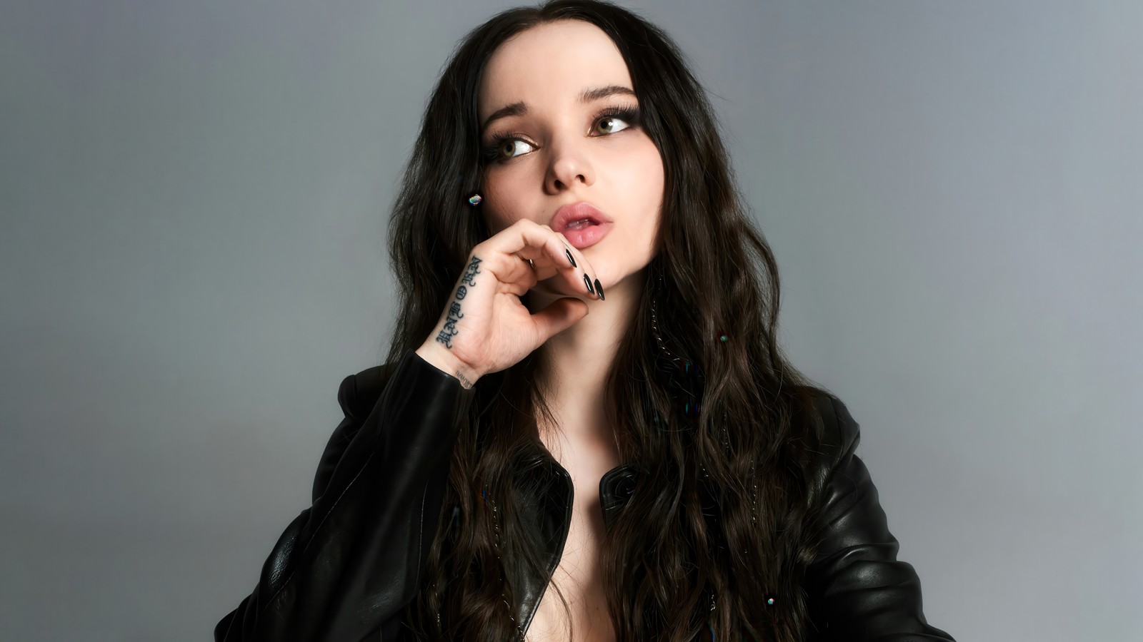 A close up of a woman with long hair and a black jacket (dove cameron, 2024, 5k, american singer, people)