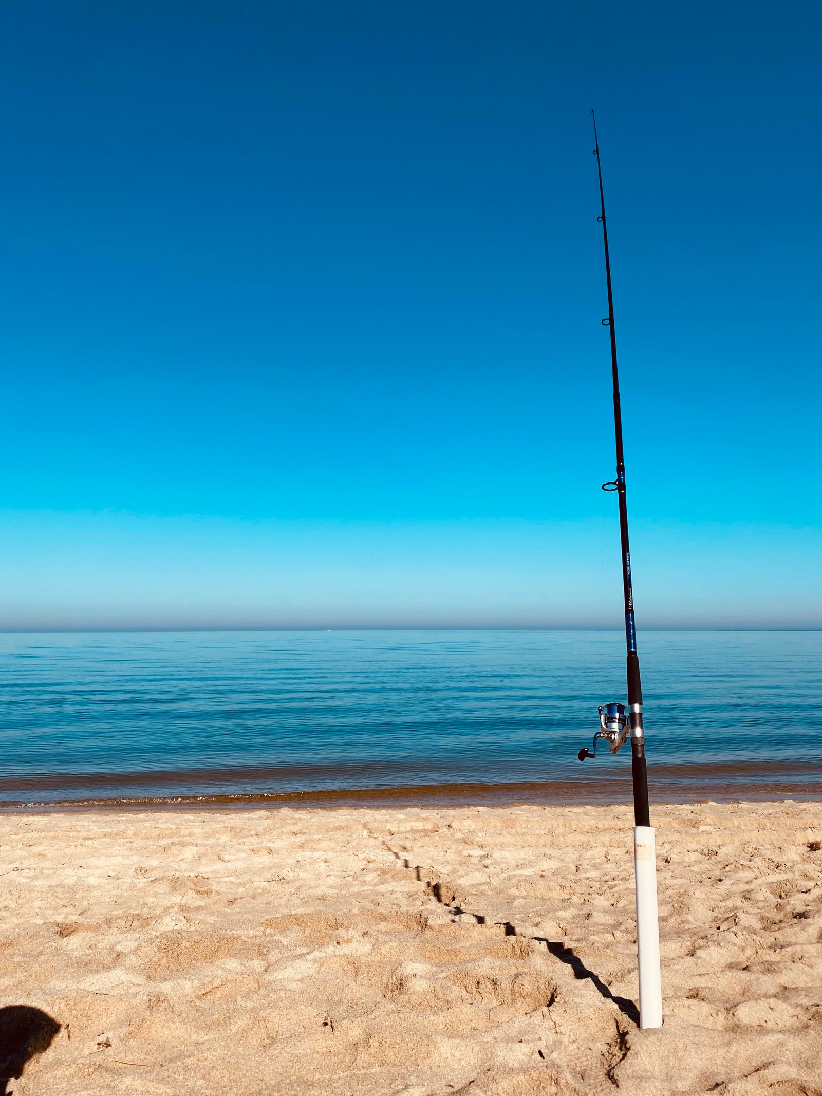 Uma vara de pescar árabe em um poste em uma praia perto do oceano (mar, água, nuvem, praia, líquido)