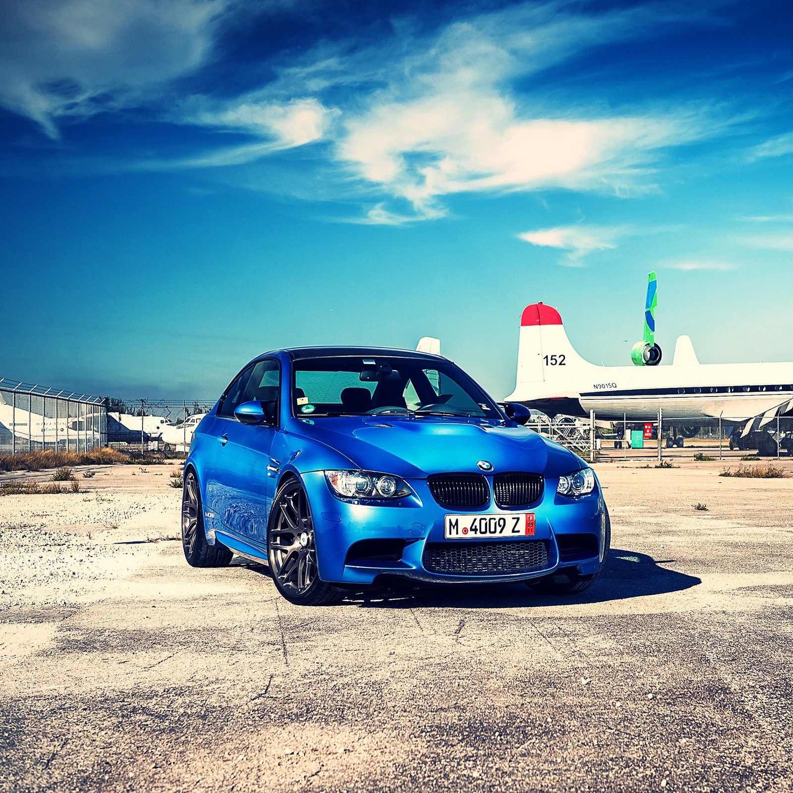 Arafed blue car parked in front of a plane on a runway (auto, bmw, car)