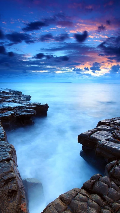 Serene Ocean Twilight Over Rocky Shoreline