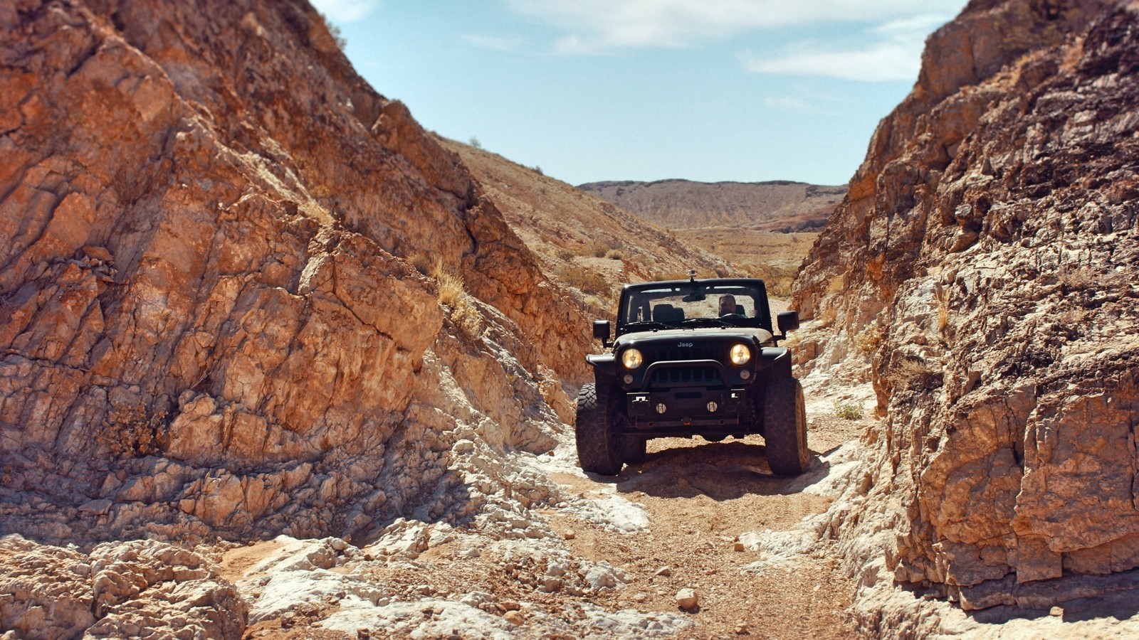 Un jeep tout-terrain roulant à travers un canyon rocheux étroit dans le désert (jeep, voiture, traction intégrale, tout terrain, roche)