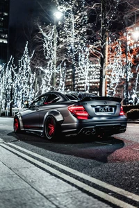 Mercedes-Benz SLS AMG en un paisaje urbano iluminado por luces festivas.