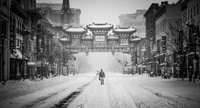 Paysage urbain enneigé avec une figure solitaire sous une arche historique