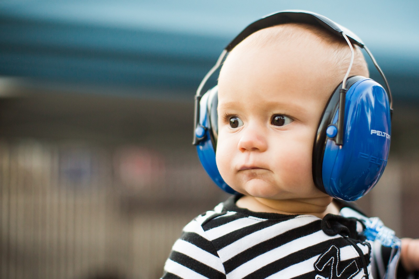 Há um bebê usando fones de ouvido e uma camisa listrada (fone de ouvido, criança, equipamento de áudio, audição, toddler)