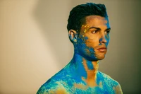 Cristiano Ronaldo com a pele pintada de azul, exibindo uma expressão focada contra um fundo neutro.