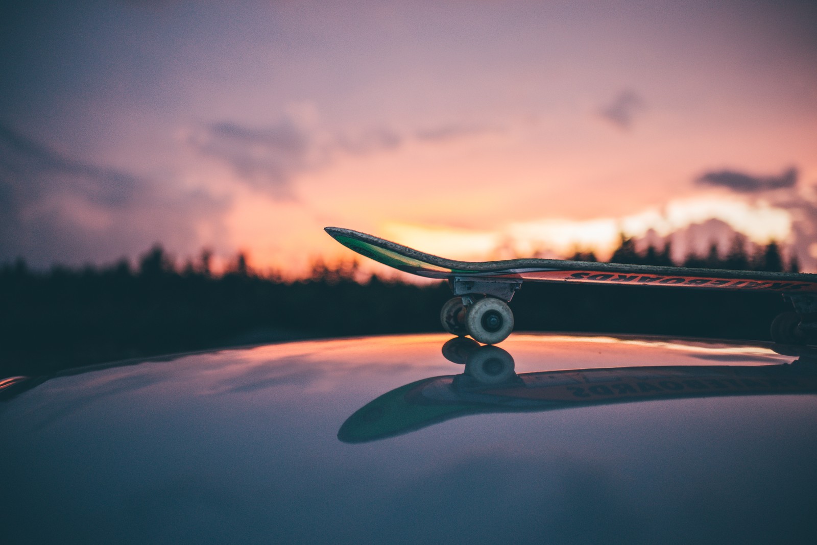 Arafed skateboard on top of a car at sunset (skateboard, skateboarding, atmosphere, cloud, wing)