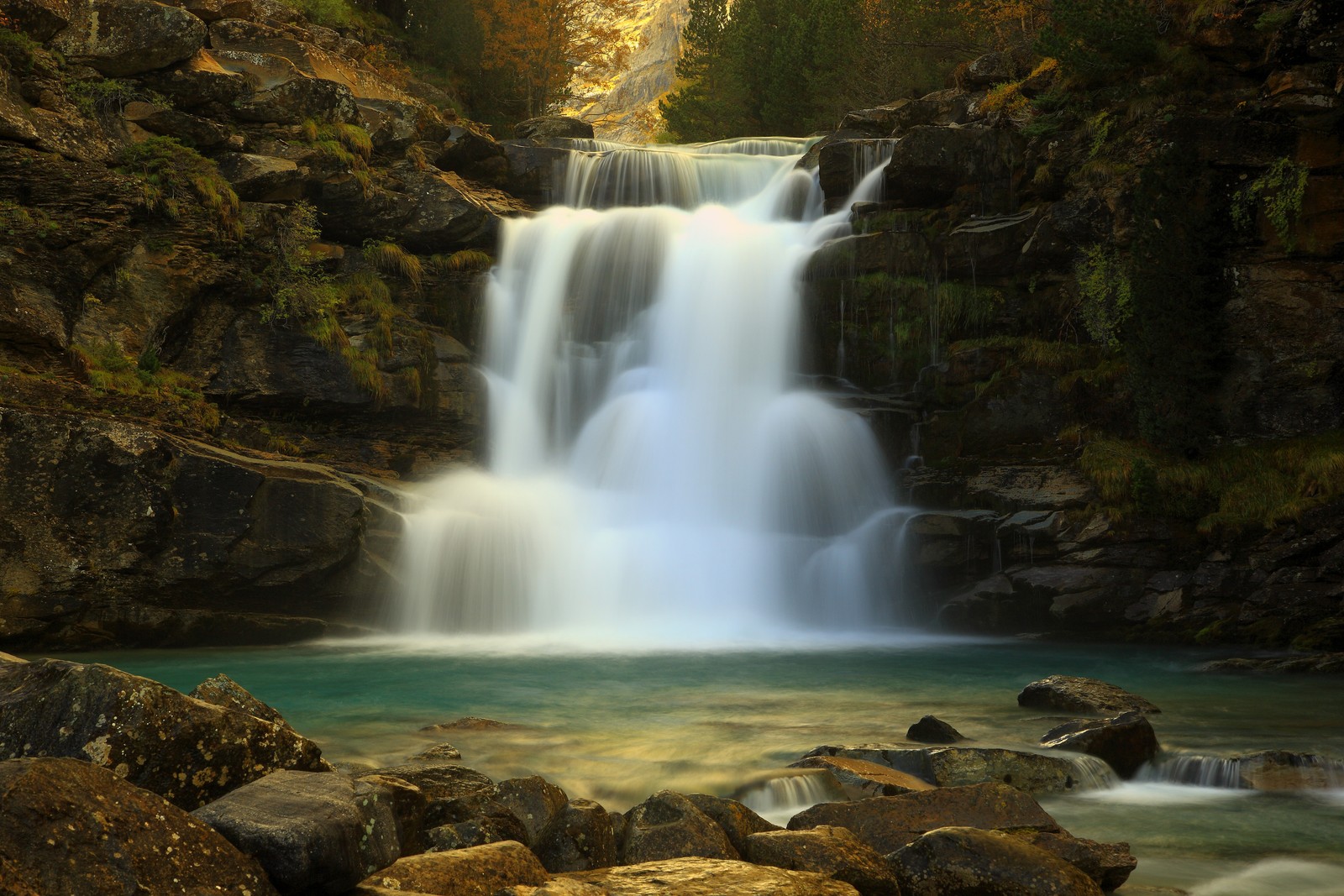 Eine nahaufnahme eines wasserfalls im wald mit felsen und wasser (wasserfall, gewässer, natur, wasser, wasserressourcen)