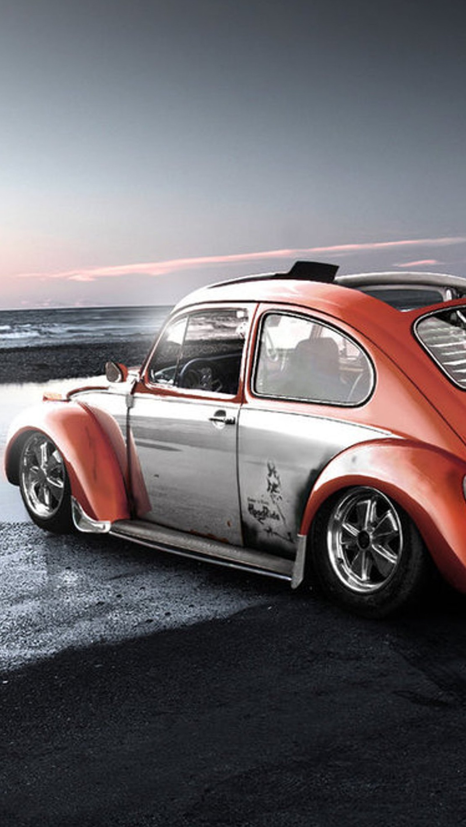 There is a red car parked on the beach with a surfboard on top (beetle, car, volkswagen)