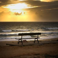 Einsame Bank am Meer bei Sonnenuntergang