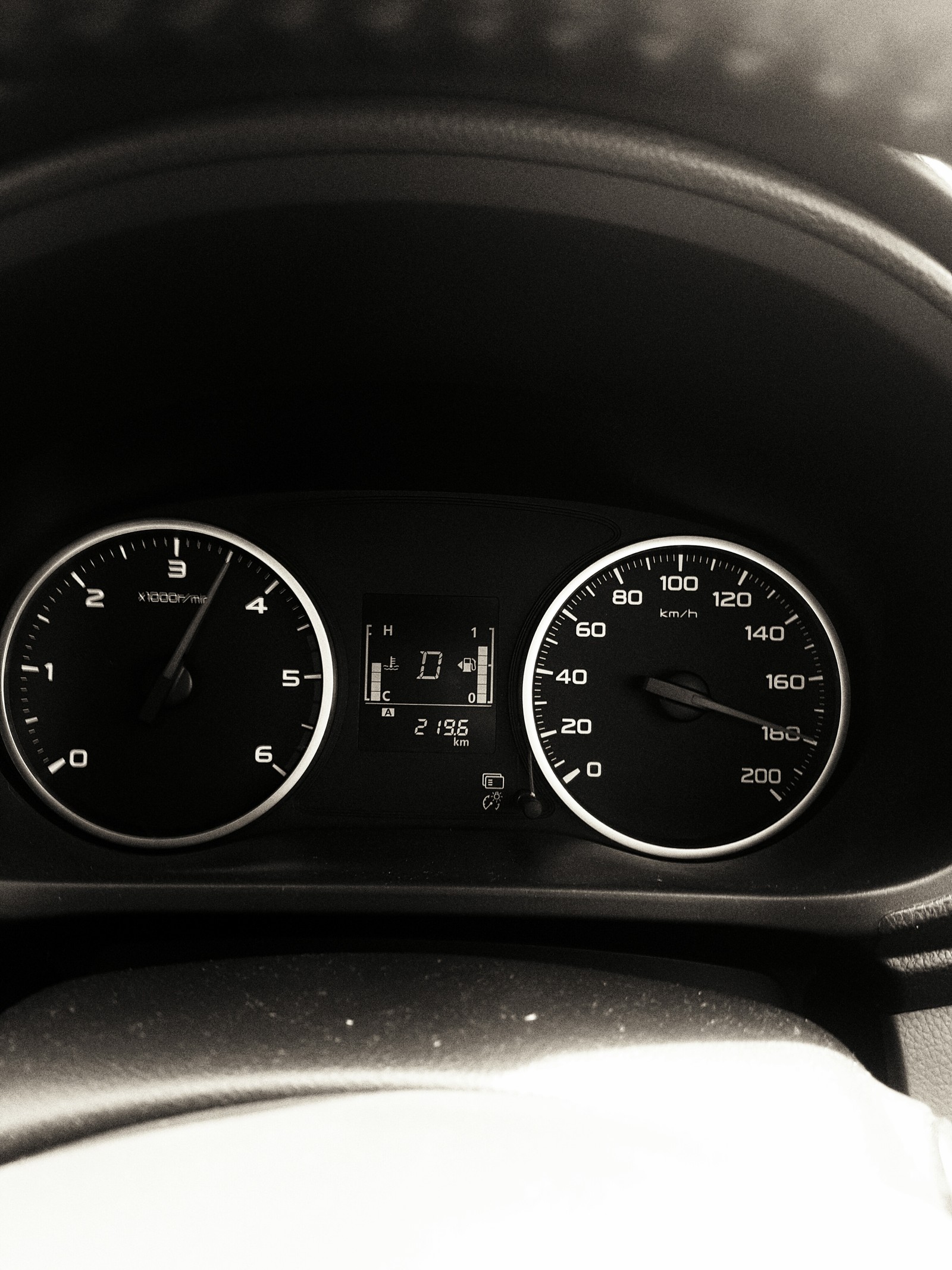 A close up of a dashboard with a clock and a speedometer (black, odometer, speed)