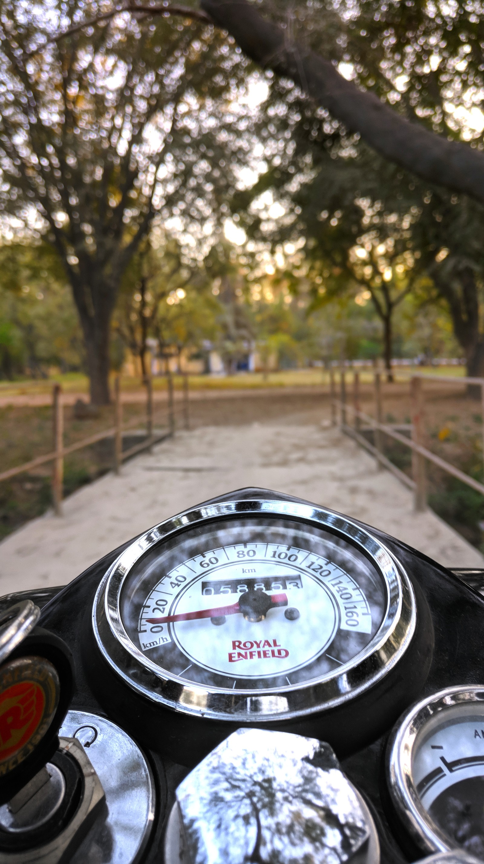 There is a motorcycle with a speedometer on the handlebars (bike, memr32, re, royal enfield)