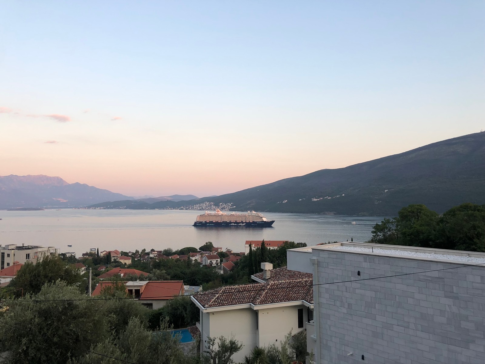 Arafed view of a large ship in the water from a hill (water, fjord, real estate, mountainous landforms, highland)