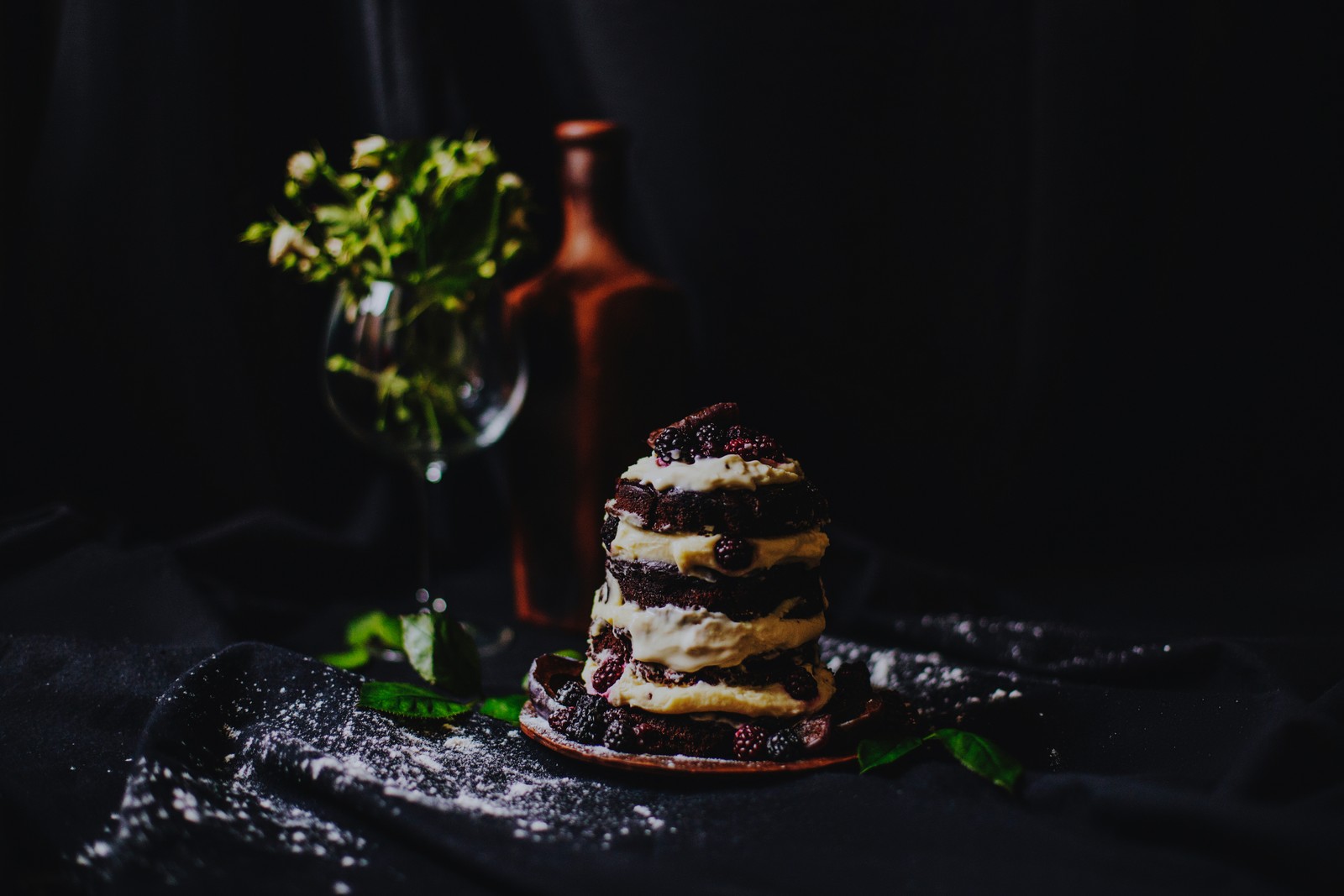 Un primer plano de un pastel en un plato con una botella de vino (pastel de chocolate, crema, postre, pastel, comida)