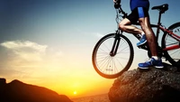 Mountainbiker bei Sonnenuntergang auf felsigem Gelände