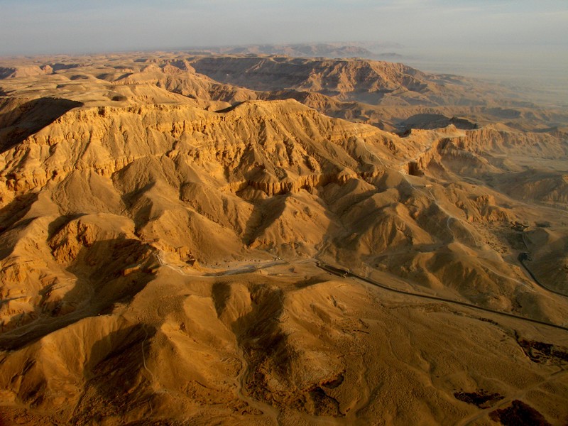 Аэрофотоснимок пустынного пейзажа с извивающейся дорогой (луксор, luxor, фараон, горные образования, бедлендс)