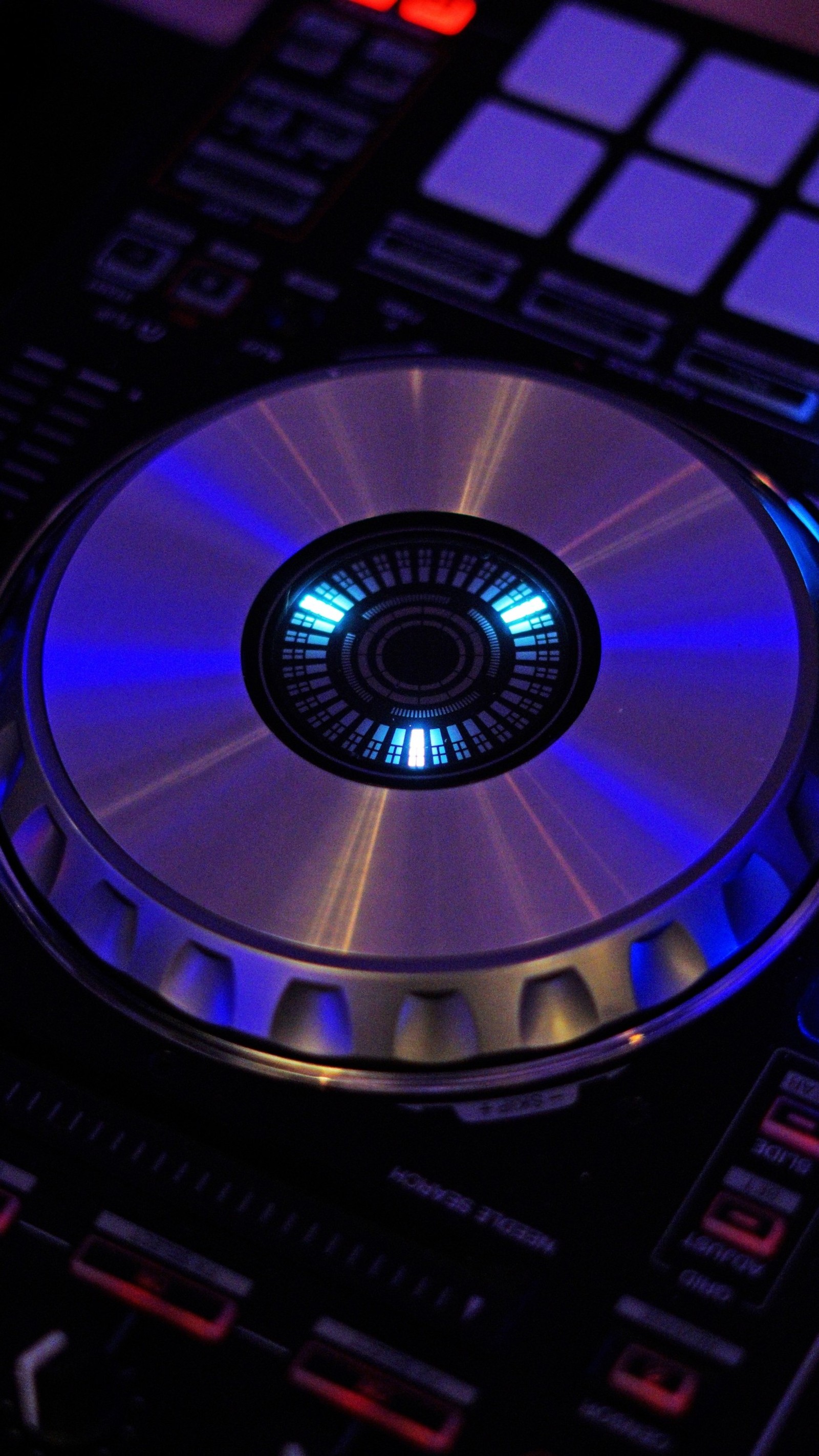 Um close de um tocador de cd com uma luz azul (roxo, tecnologia, círculo, pioneiro, mixador de dj)