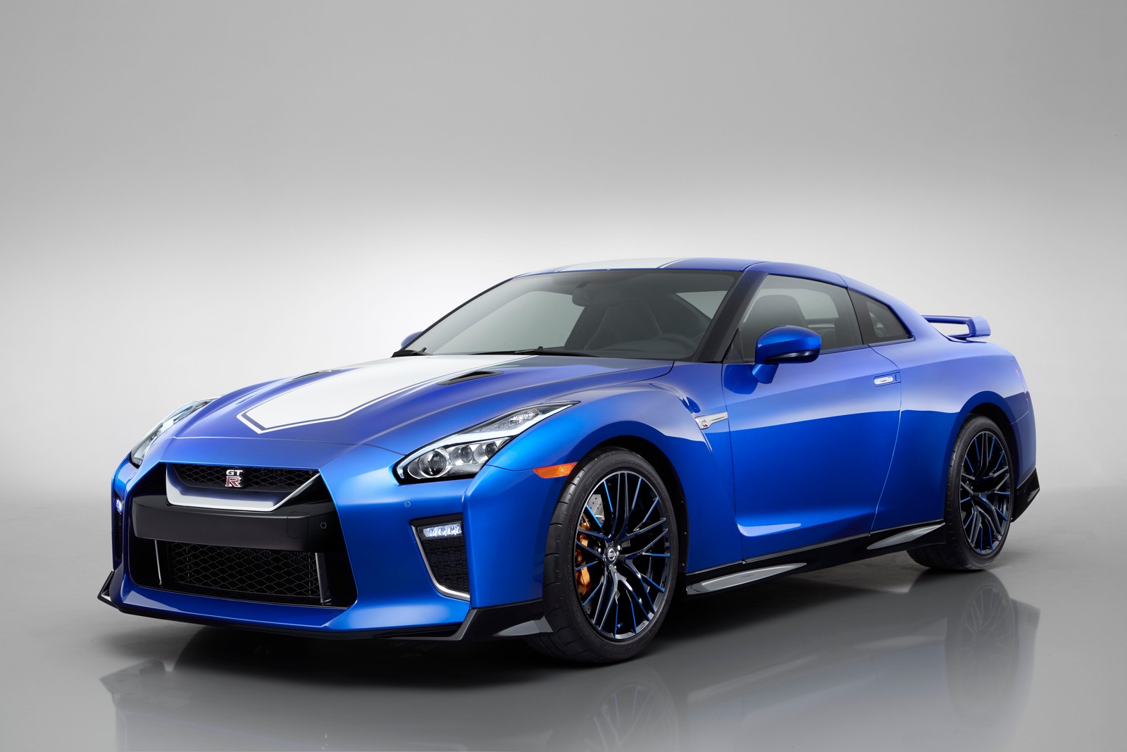 A blue sports car is shown in a studio setting (nissan, car, sports car, supercar, coup)