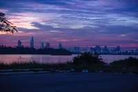 Paisagem urbana ao crepúsculo: Um pôr do sol vibrante sobre o horizonte