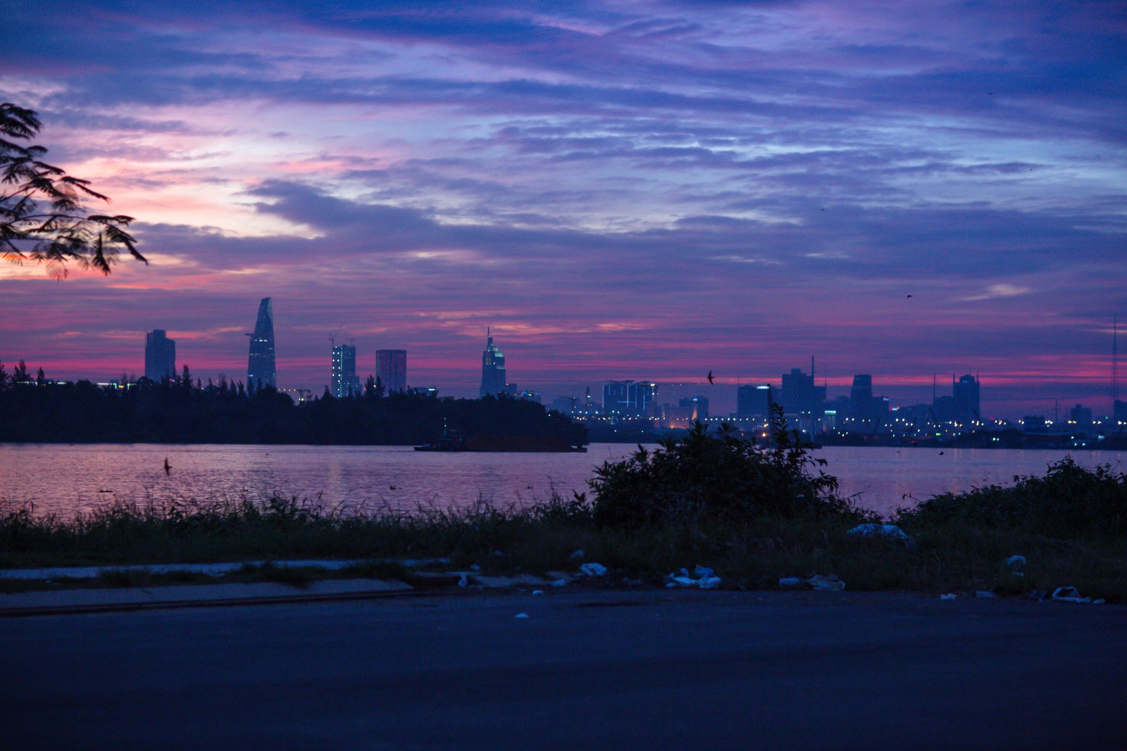 Vue de la silhouette de la ville au crépuscule avec un lac au premier plan (coucher de soleil, nuage, horizon, ville, crépuscule)