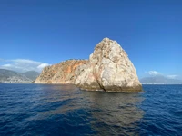 Majestuosa formación rocosa costera contra un cielo azul claro