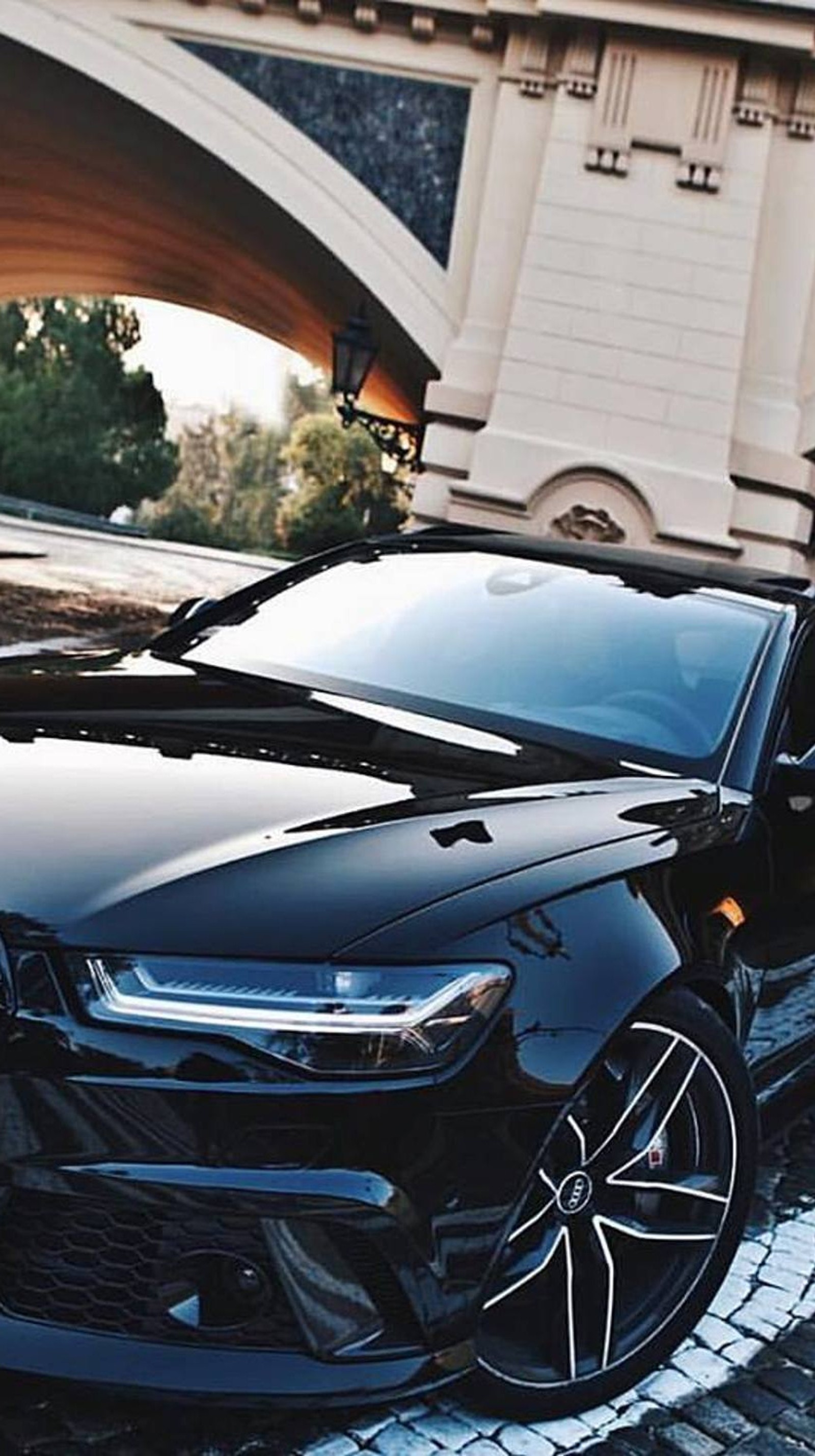 A close up of a black car parked on a brick road (audi, car, rs6)