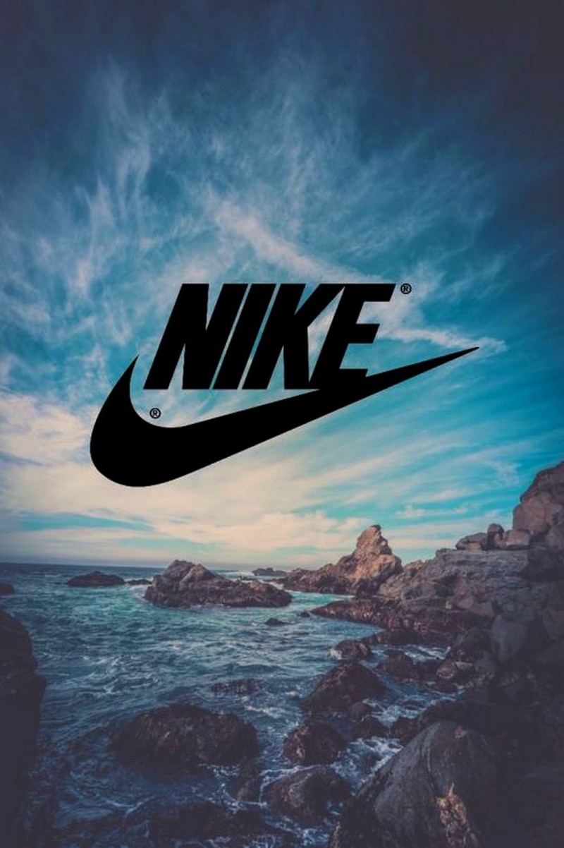 Черный логотип nike на каменистом пляже с океаном на заднем плане (воздух, фон, лучший, крутой, логотип)