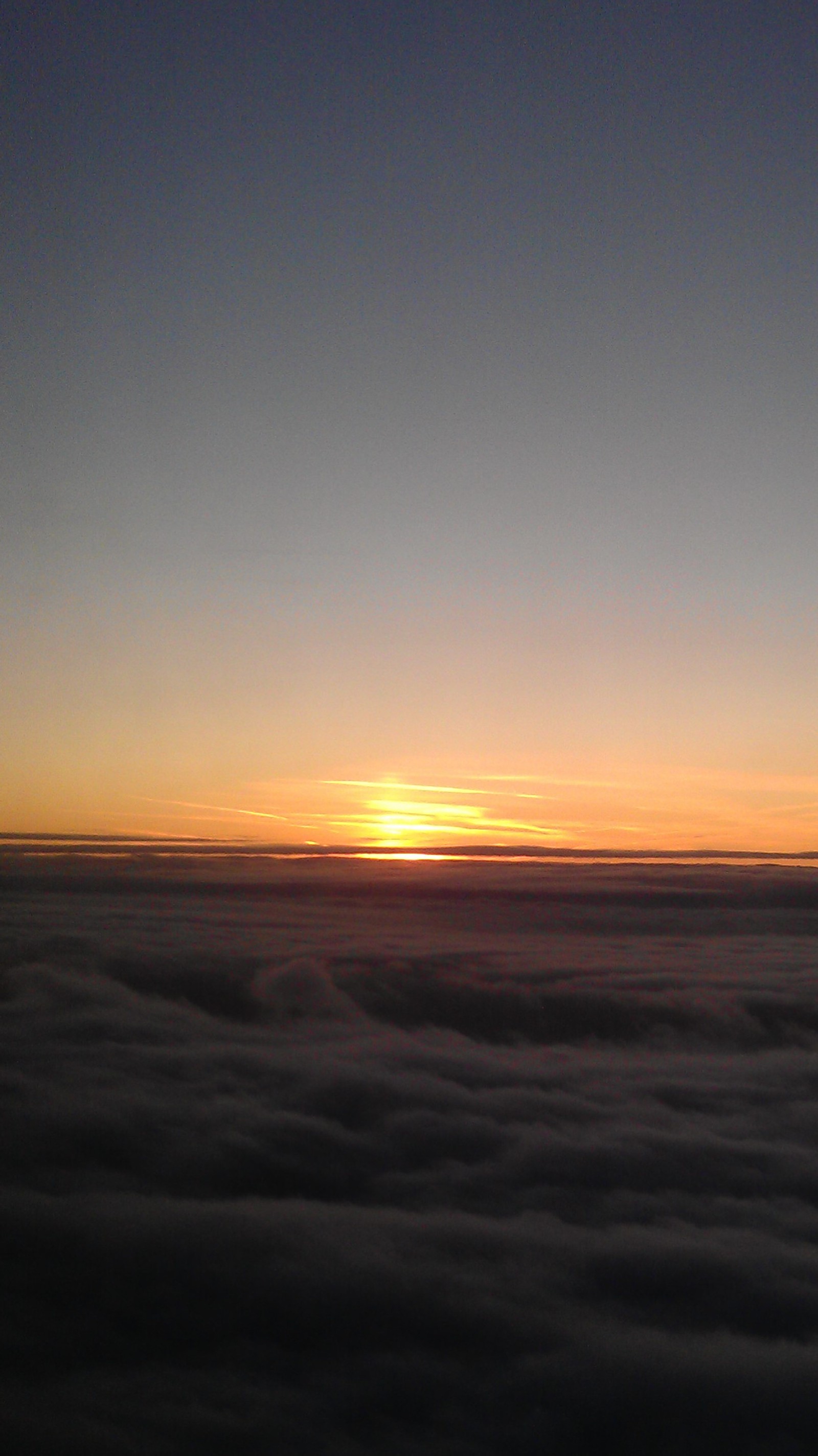 Vista aérea de um pôr do sol sobre um mar de nuvens (nuvens, noite, sol, por do sol)