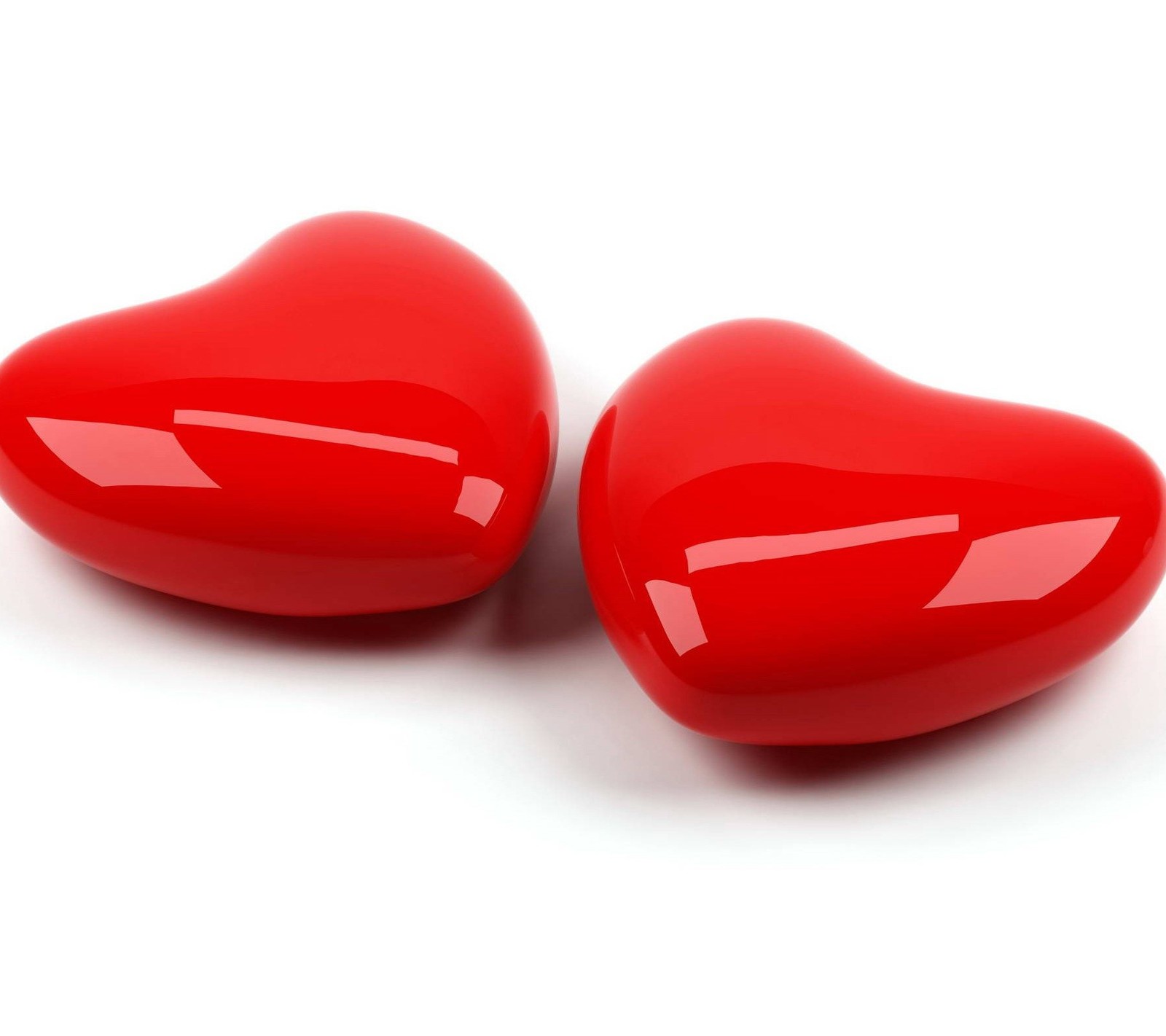 Two red hearts are sitting on a white surface (hearts, love)