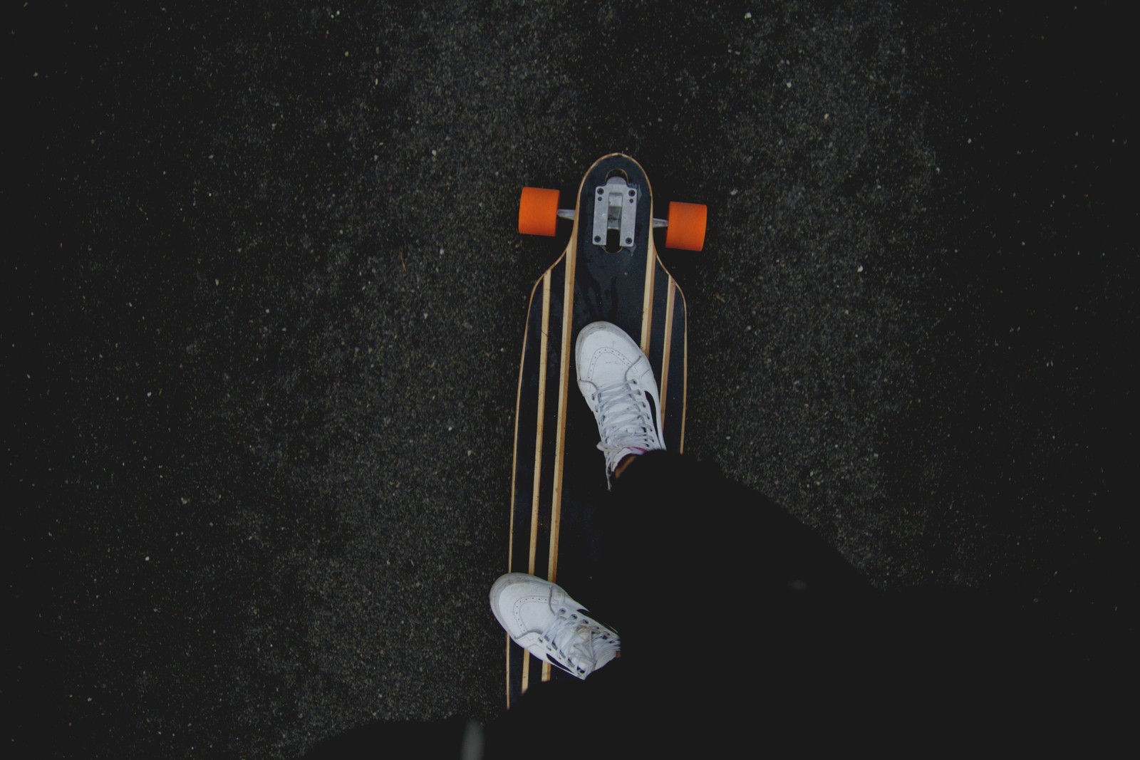 Someone standing on a skateboard with their feet on the board (skateboard, longboard, skateboarding, space, sports)