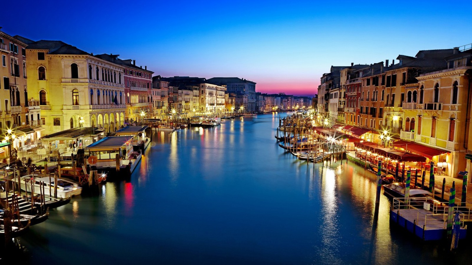 Una vista de un canal con barcos y edificios de noche (gran canal, vía fluvial, canal, reflexión, pueblo)