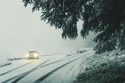 Auto, das eine verschneite Straße in einem Wintersturm navigiert