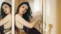 Emma Dumont em uma sessão de fotos glamourosa, exibindo elegância e atração.