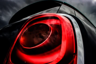 Red Automotive Headlamp Against a Dramatic Sky