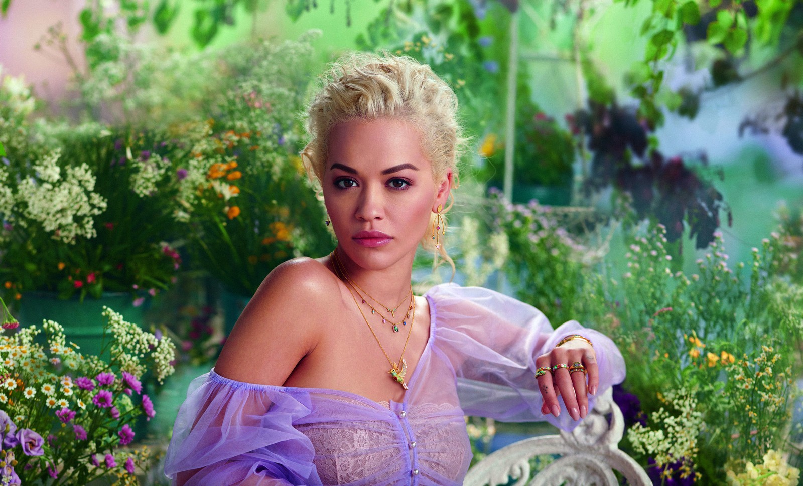 Femme girafe en robe violette assise sur un banc dans un jardin (rita ora, séance photo, chanteur britannique, beau, gens)